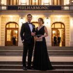 Elegantní pár v večerním oblečení před filharmonií večer, vhodné pro průvodce etikou a dress codem