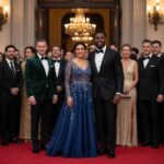 Skupina lidí v elegantním oblečení na červeném koberci před luxusním vstupem na slavnostní akci